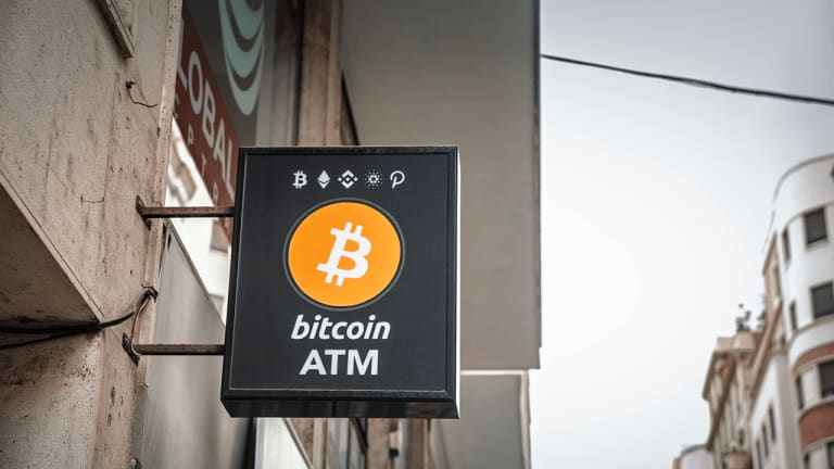 A row of crypto ATM kiosks in a storefront, with one machine marked out of service